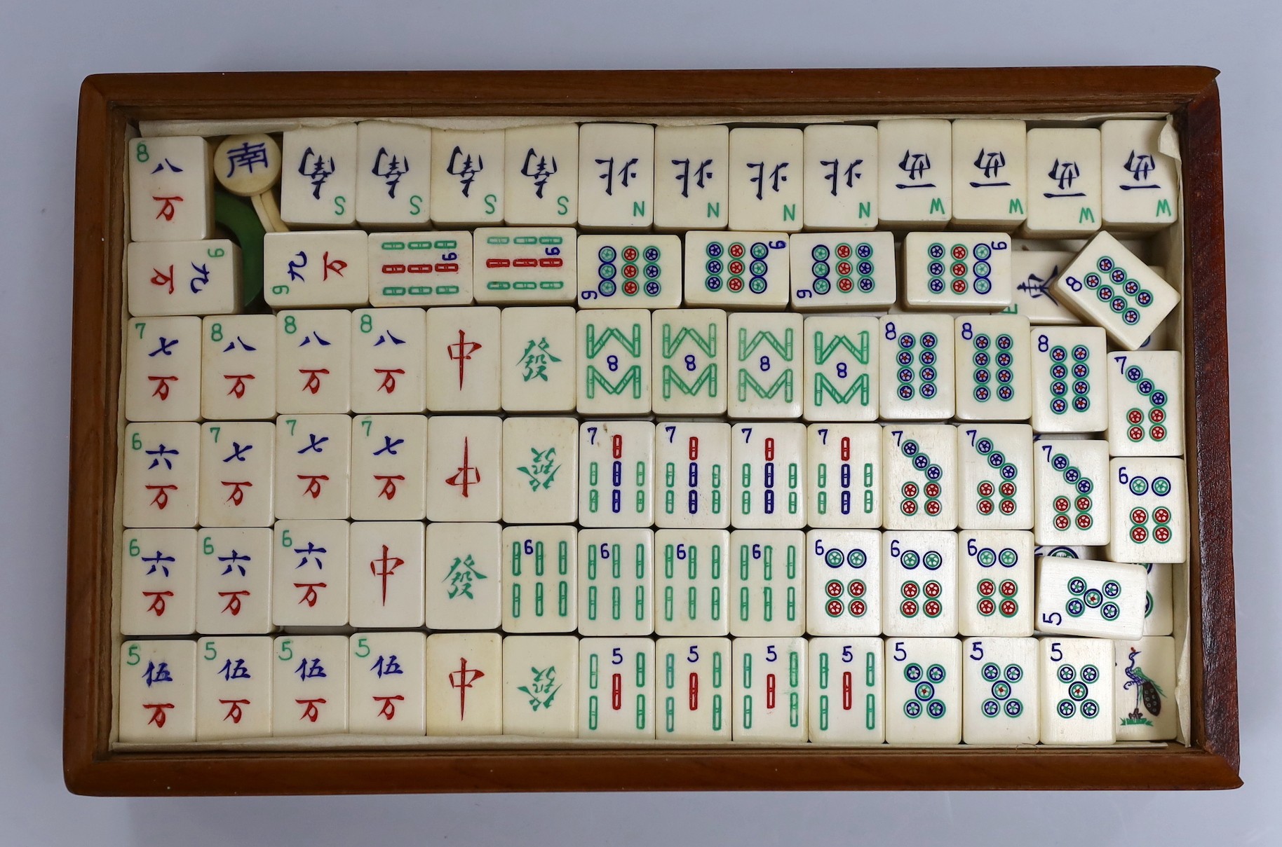 An early 20th century Chinese bone and bamboo mah jong set in two hardwood slide top boxes, largest 26.5cms wide x 5cms high